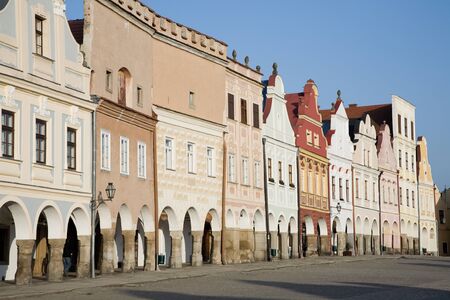 Facade of old city houses with arcades on square の写真素材