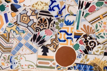 Closeup of chaotic Gaudi pink mosaic on seat in Parc Guel in Barcelona.の写真素材