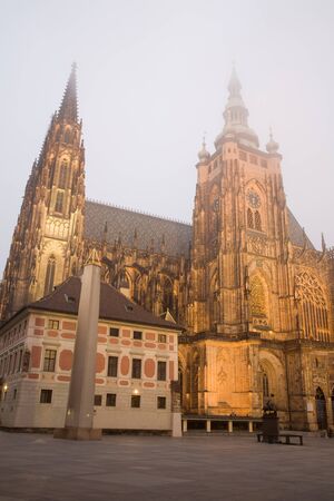 Gothic towers of the famous cathedral of St. Vitus in Prague are touching the fog.の写真素材