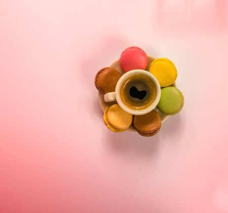 Delicious black coffee in a beautiful ceramic cup and saucer with delicious macaroonsの写真素材