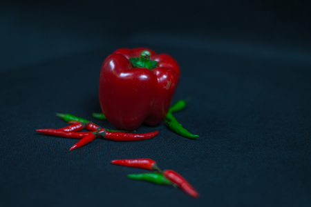 artistic decoration with fresh small red, green peppers and two bells pepper, fresh vegetables, chili peppers, spicy and hotの写真素材