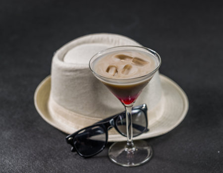 colored drink, a combination of red, beige and violet, martini glass, black sunglasses, white stylish hat, party setの写真素材