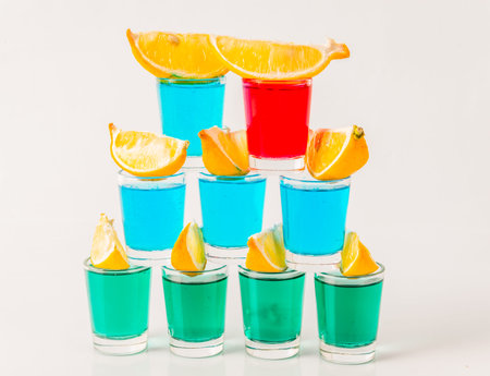 Glasses with blue, green and red kamikaze, glamorous drinks, mixed drink poured into shot glasses, party setの写真素材