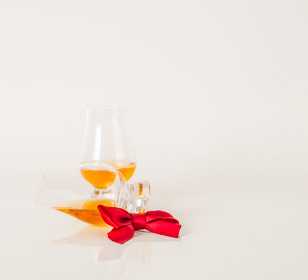 Set of single malt tasting glasses, single malt whisky in a glasses, white background, red bow,...