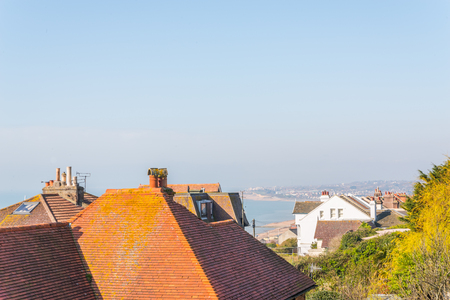 Roofs of buildings in a seaside village, ocean view, sunny day, clear skyの写真素材