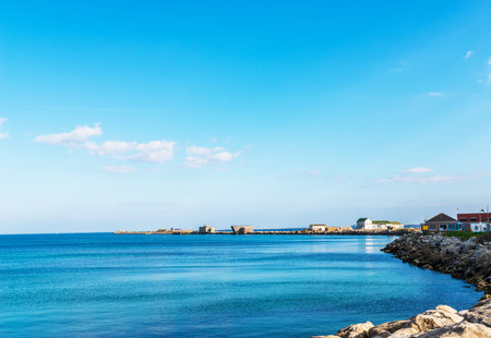 Ocean view and stone pier, buildings and stones on the shore, ocean viewの写真素材
