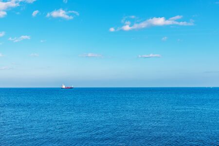 A view of the enormous ocean, in the distance a flowing ship, beautiful blue sky in contact with clean water, ocean viewの写真素材