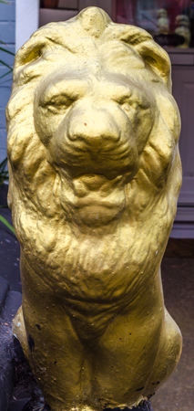 Stone lion painted in gold color, sculpture at the entrance of the building, architecture decoration, vintageのeditorial素材