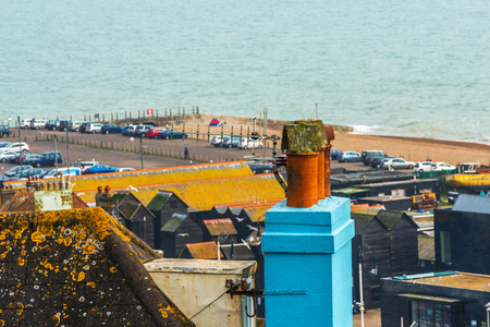 Blue chimney and roofs of buildings covered with green moss, seaside spot seen from the bird's eye view, beautiful typical English architecture, top viewのeditorial素材