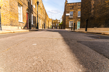 Typical old English buildings, low brick buildings across a narrow street, interesting old London architecture, english housesの写真素材