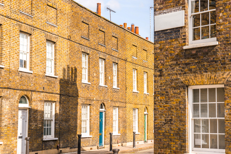 Typical old English buildings, low brick buildings across a narrow street, interesting old London architecture, english housesの写真素材