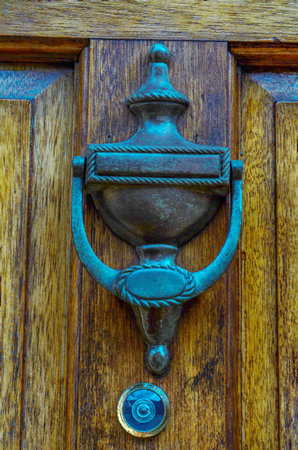 Door with brass knocker in the shape of a decor, beautiful entrance to the house, home decor
