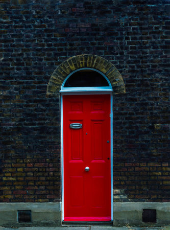 stylish entrance to a residential building, an interesting facade of the old brick arches above the door, a typical old English buildings, londonの写真素材