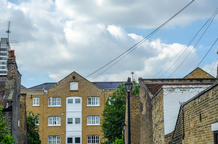 Typical old English buildings, low brick buildings across a narrow street, interesting old London architecture, english housesの写真素材
