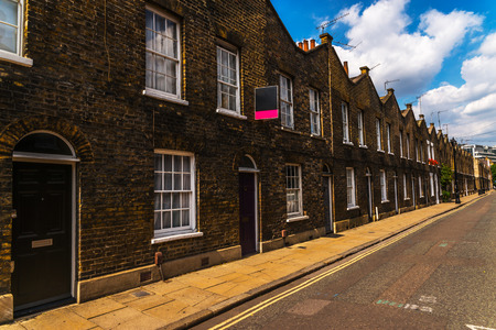Typical old English buildings, low brick buildings across a narrow street, interesting old London architecture, english housesのeditorial素材
