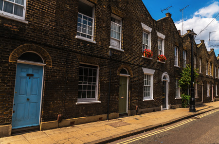 Typical old English buildings, low brick buildings across a narrow street, interesting old London architecture, english housesのeditorial素材