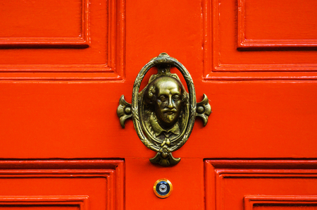 Door with brass knocker in the shape of a human's head, beautiful entrance to the house, decorの写真素材