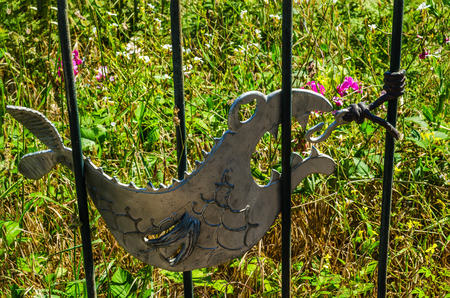 metal ornament on a balustrade in a seaside village, symbolic in the shape of a fish, ocean and plains, decorの写真素材