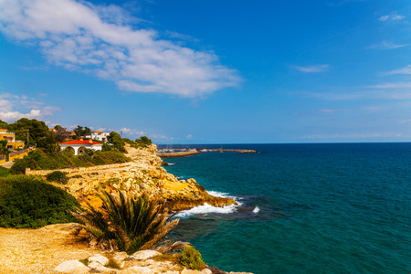 high cliff above the sea, summer sea background, many splashing waves and stone, sunny dayの写真素材
