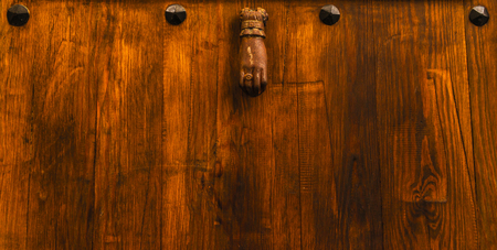 Door with brass knocker in the shape of a hand, beautiful entrance to the house, decorの写真素材