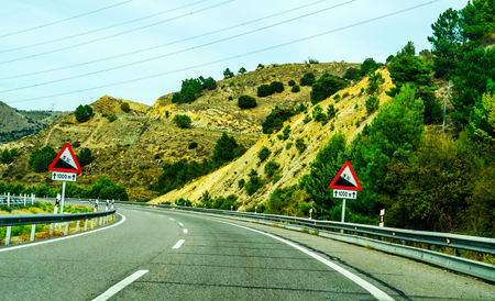 Fast road in the mountains in Spain, beautiful landscape of mountains, dry earth and rock from the sun, transportationの写真素材