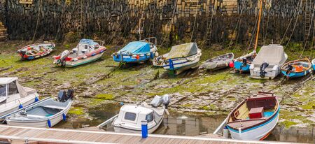 Boats  in a little harbor during an outflow, low water level, fishing industryの写真素材