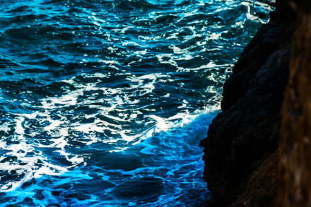 high cliff above the sea, summer sea background, many splashing waves and stone, sunny day