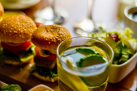 mini burgers with meat, vegetables, cheese and other toppings, bread sprinkled with sesame seeds, mini fast food, tasty setの写真素材