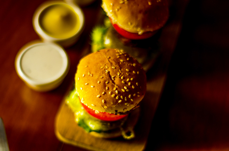 mini burgers with meat, vegetables, cheese and other toppings, bread sprinkled with sesame seeds, mini fast food, tasty setの写真素材