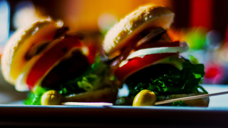 mini burgers with meat, vegetables, cheese and other toppings, bread sprinkled with sesame seeds, mini fast food, tasty setの写真素材