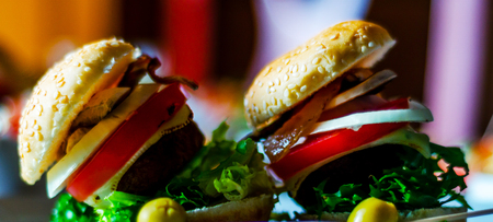 mini burgers with meat, vegetables, cheese and other toppings, bread sprinkled with sesame seeds, mini fast food, tasty setの写真素材