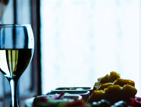 white wine in a glass with appetizers on a wooden table, a set of starters, relax with a glass of wine, white wineの写真素材