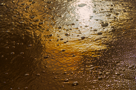 close up of the sea water affecting the sand on the beach, sea waves calmly flowing sand, relaxing view, summer timeの写真素材