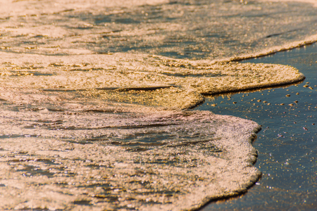 close up of the sea water affecting the sand on the beach, sea waves calmly flowing sand, relaxing view, summer timeの写真素材