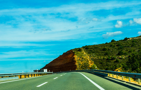 Fast road in the mountains in Spain, beautiful landscape of mountains, dry earth and rock from the sun, transportationの写真素材