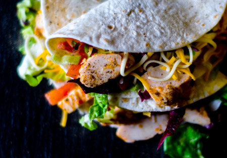 Tasty fresh wrap sandwich with meat, vegetables and cheese, delicious snack, healthy foodの写真素材