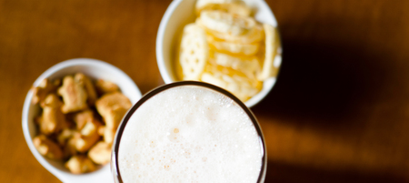 pint of lager beer in a glass, set of various snacks, a standard set of drinking and eating in a pub, beer and snacksの写真素材