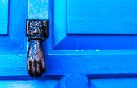 Door with brass knocker in the shape of a hand, beautiful entrance to the house, decorの写真素材