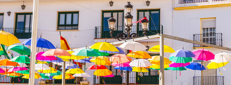 Colourful umbrellas urban street decoration. Hanging colorful umbrellas over blue sky, tourist attraction, sunny dayの写真素材