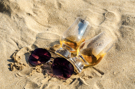 Glass of whiskey single malt on the sand beach, a glass of tasting, relax on the beach, vacation