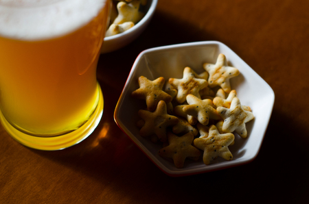 Pint of lager beer in a glass, set of various snacks, a standard set of drinking and eating in a pub, beer and snacksの写真素材