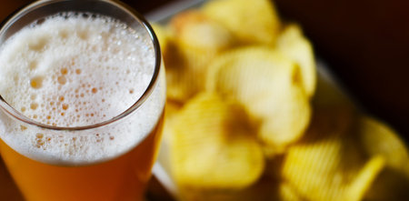 Pint of lager beer in a glass, set of various snacks, a standard set of drinking and eating in a pub, beer and snacksの写真素材