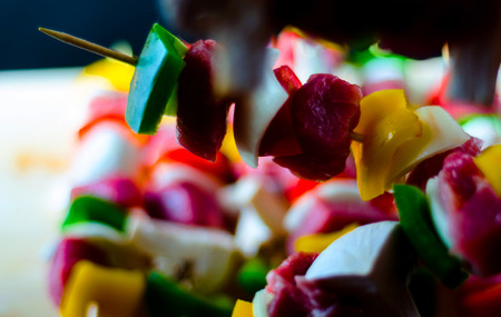 Skewers with meat and vegetables prepared for grilling on a wooden board, colorful and tasty dishの写真素材