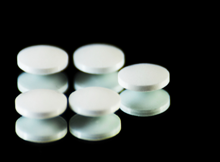 Scattered tablets on a black background, pills reflected in the mirror, medicineの写真素材