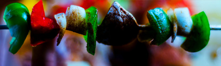 Skewers with meat and vegetables prepared for grilling on a wooden board, colorful and tasty dishの写真素材