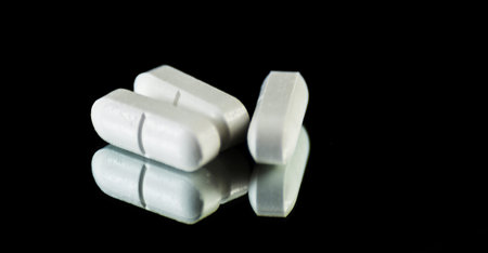 Scattered tablets on a black background, pills reflected in the mirror, medicineの写真素材