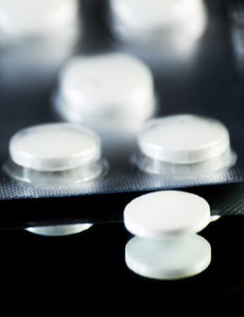 scattered tablets on a black background, pills reflected in the mirror, medicineの写真素材