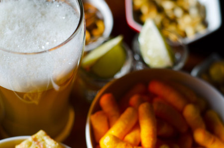 pint of lager beer in a glass, set of various snacks, a standard set of drinking and eating in a pub, beer and snacksの写真素材