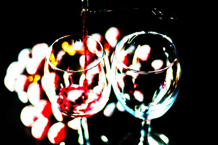 pouring red wine in a glass, celebration of a moment with a glass of wine, exquisite liquor for gourmets, wineryの写真素材