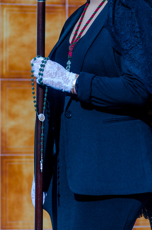 Rosary held by a woman in a black dress and white gloves, symbol of faith, christianityの写真素材